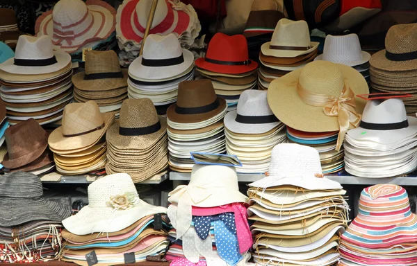 Trh stánek s mnoha klobouky slaměné klobouky na prodej — Stock fotografie