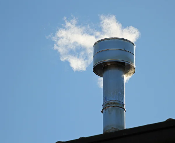 Schornstein auf dem Dach mit Rauch aus dem Heizkessel — Stockfoto