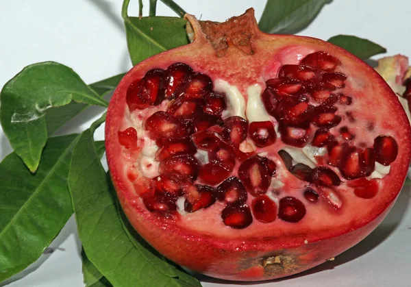 Pomegranate red ripe with beans very juicy and leaves — Stock Photo, Image