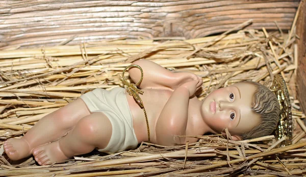 Baby jesus je položen v kolébce v jeslích — Stock fotografie