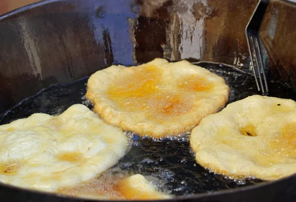 Sabrosos buñuelos de manzana fritos en el caldero de aceite hirviendo en sal — Foto de Stock
