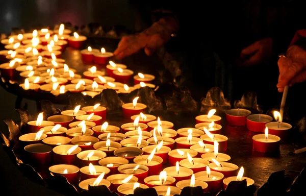 Muchas velas de cera encendidas por los fieles durante la celebración de t —  Fotos de Stock