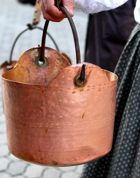 Panela de cobre transportada por uma mulher camponesa para a aldeia rural — Fotografia de Stock
