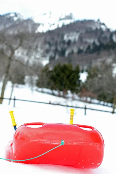 Bob rouge en plastique robuste sur neige blanche pour des promenades amusantes — Photo