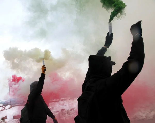 Protest mit Demonstranten in schwarzen Gewändern mit grünem Rauch — Stockfoto
