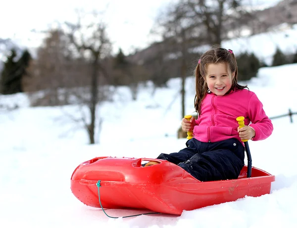 Mooi klein meisje met ski pak met de bob op berg — Stockfoto