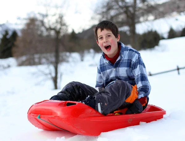 Cute boy has fun with bob on snowy mountain — Stock Photo, Image