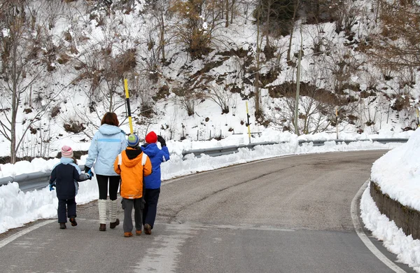 Mladá rodina se třemi dětmi, chůze po silnici pokryté sněhem v — Stock fotografie