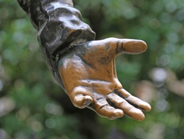 bir şeyler sunmak için bronz el uzanır