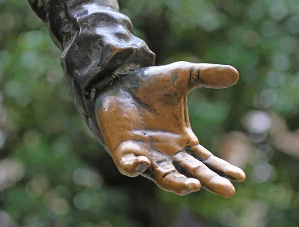 La mano de bronce se estira para ofrecer algo — Foto de Stock