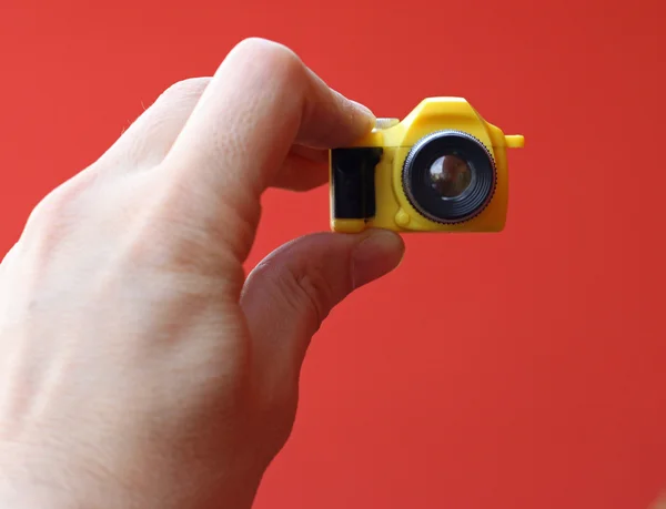 Fotógrafo enquanto em um auto-temporizador com uma pequena câmera de brinquedo — Fotografia de Stock