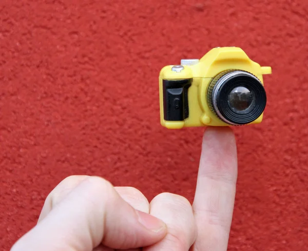 Kleiner Finger mit kleiner Spielzeugkamera — Stockfoto