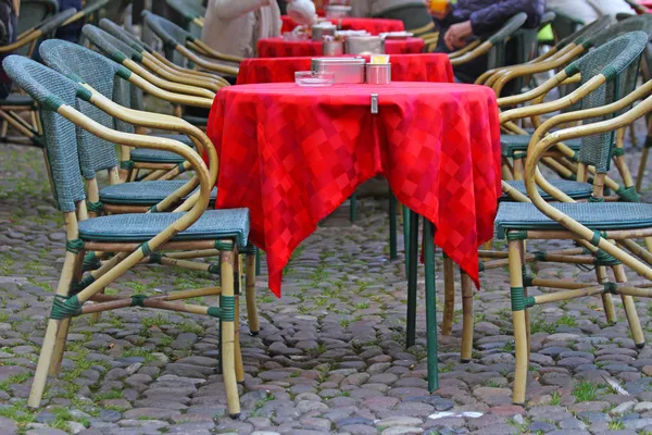 Toalha de mesa vermelha sobre as mesas de um café para abrir em um c europeu — Fotografia de Stock