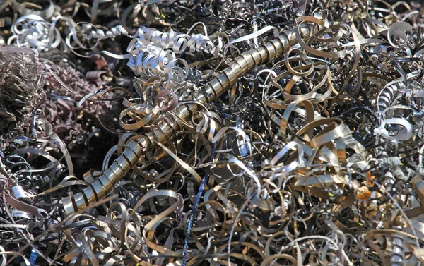 Curls and shavings discarded pieces of iron and zinc in steel du — Stock Photo, Image