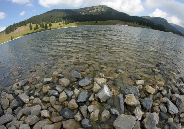 Lago alpino rodeado de altas montañas — Foto de Stock