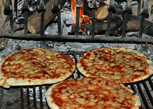 Pizza gebakken in een houten openhaard — Stockfoto