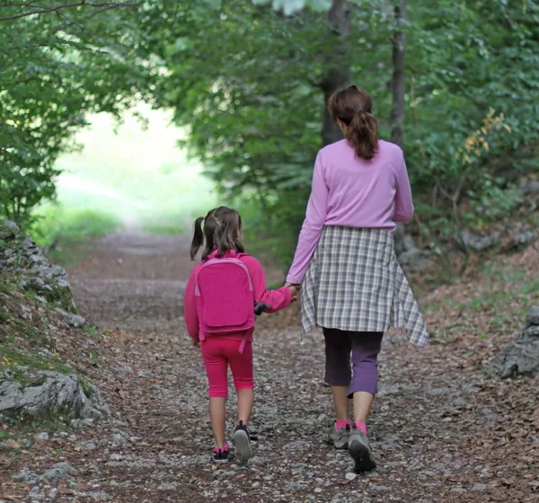 Maman et fille tenant la main marchant — Photo