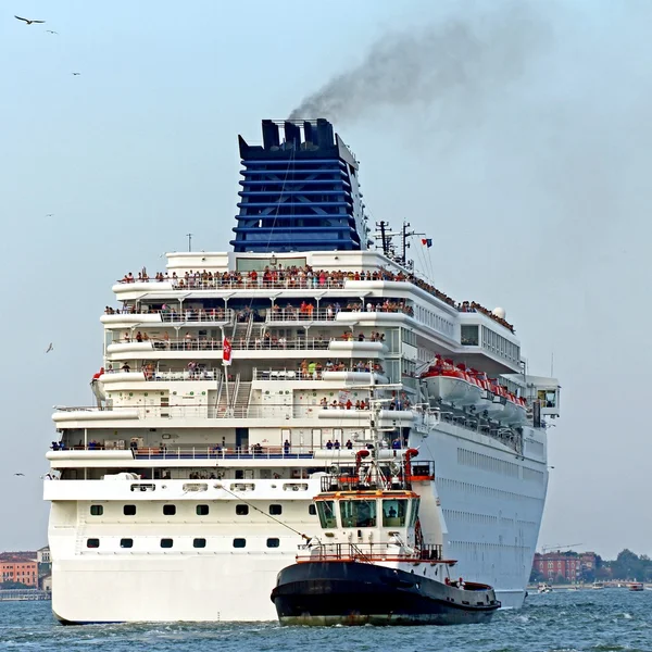Tugboat while accurately manoeuvre the cruise ship out of the po — Stock Photo, Image