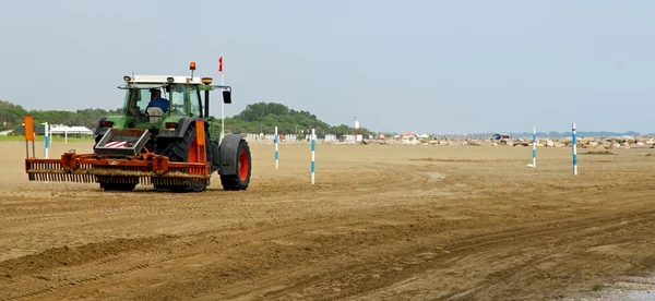 Трактор очищає пляж після шторму — стокове фото