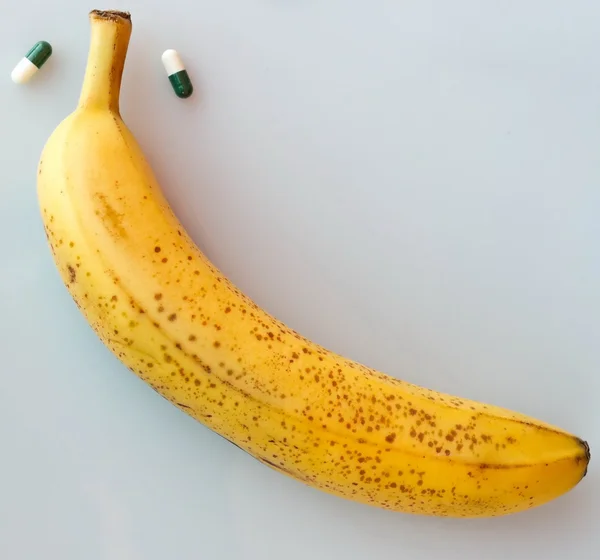 Banana amarela enorme com pílulas — Fotografia de Stock