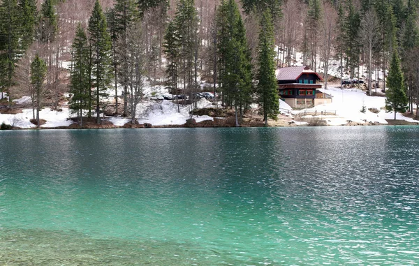 Cabaña alpina en la orilla del lago con agua dulce y Crystal — Foto de Stock