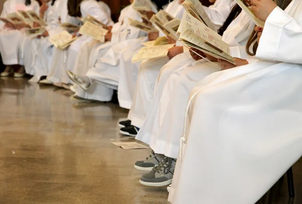 Enfants avec des tuniques blanches de première communion à la messe — Photo