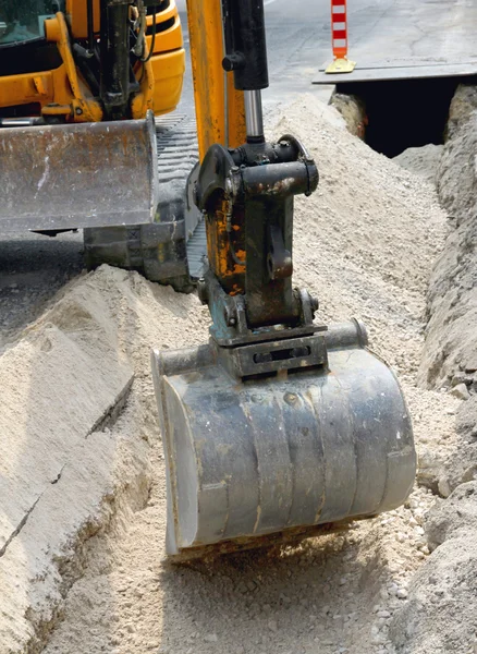 Gran cubo de una excavadora durante la excavación en la carretera —  Fotos de Stock