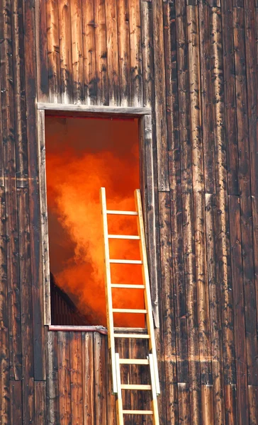 Orange füst szivárog a fából készült ház alatt a tüzet — Stock Fotó