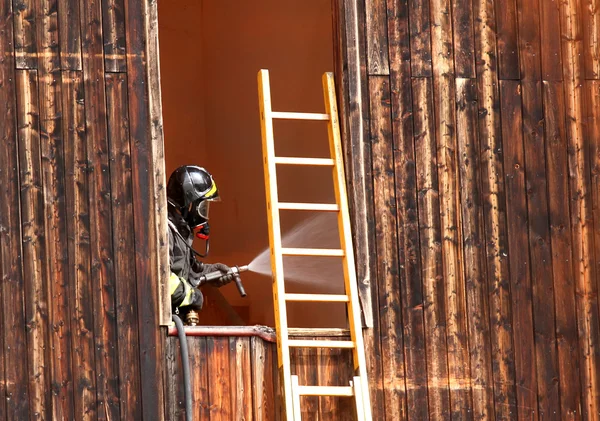 Pompier intrépide avec bouche d'incendie en action offre beaucoup de w — Photo