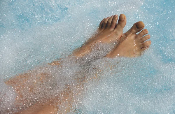 Les pieds des femmes dans la piscine à la circulation veineuse — Photo