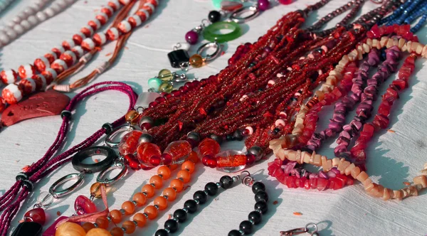 Красные ожерелья с другими ювелирными изделиями на продажу в винтажном магазине — стоковое фото