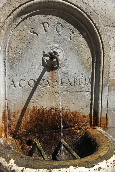 Roma, una antigua fuente de mármol con agua que fluye y SPQR — Foto de Stock