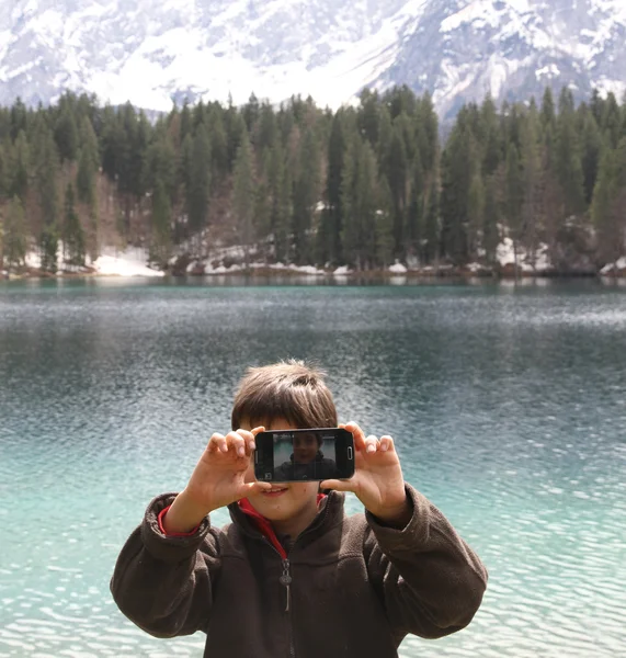 Enfant souriant prendre une photo avec minuterie d'un très technolog — Photo