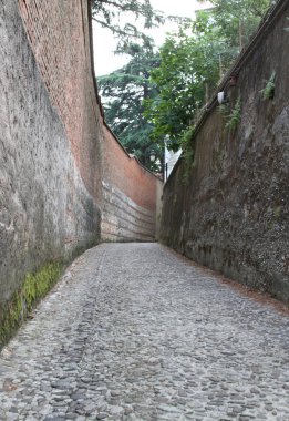 Arnavut kaldırımlı yol, tuğla duvarlarla sınırlanan