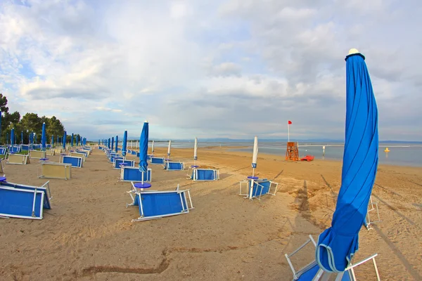 Closed umbrellas on the beach of the Adriatic Sea in summer — Stock Photo, Image