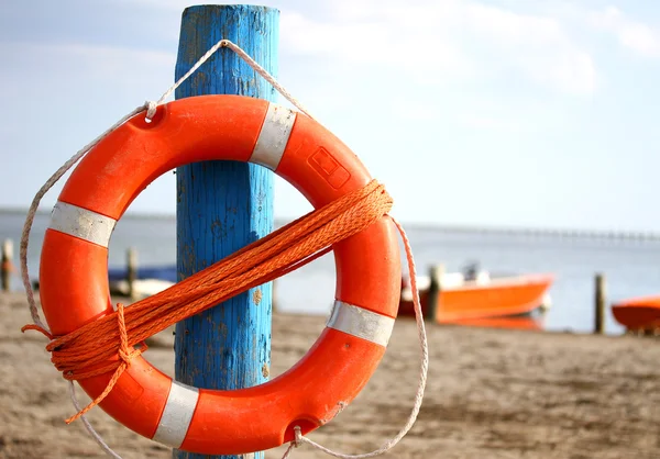 Pole with lifejacket at sea on the beach by the sea — Stock Photo, Image
