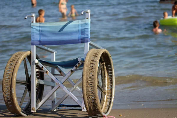 Silla de ruedas con ruedas de acero para entrar en el mar para personas con di —  Fotos de Stock