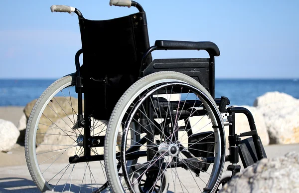 Rolstoel op de rotsen van de blauwe zee in de zomer — Stockfoto