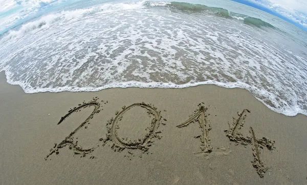 Ola que borra 2014 año escrito en la playa del mar 1 —  Fotos de Stock