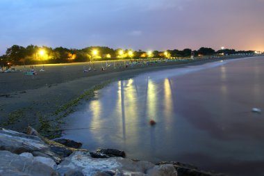 night view of the beach with lit clipart