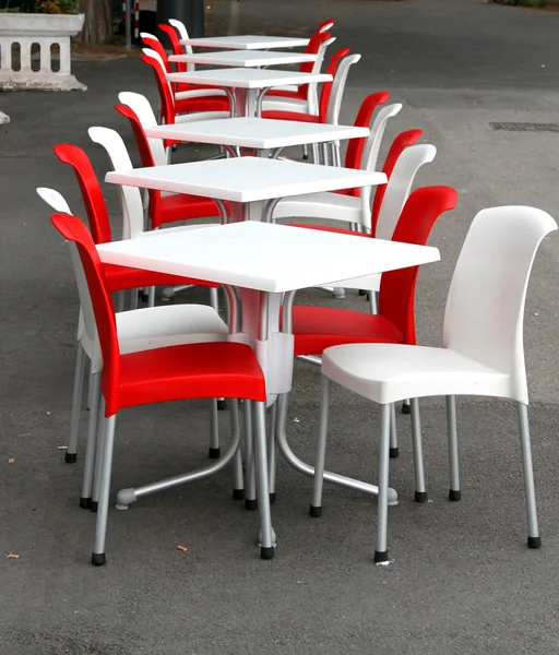Cadeiras vermelhas e brancas com mesas em um bar ao ar livre na estrada — Fotografia de Stock