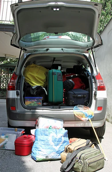 Trunk overloaded with  bags for vacation with a fishing net — Stock Photo, Image