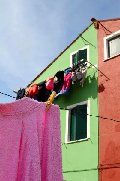 Rosa Baumwollbademantel zum Trocknen ausgelegt und die bunten Häuser — Stockfoto