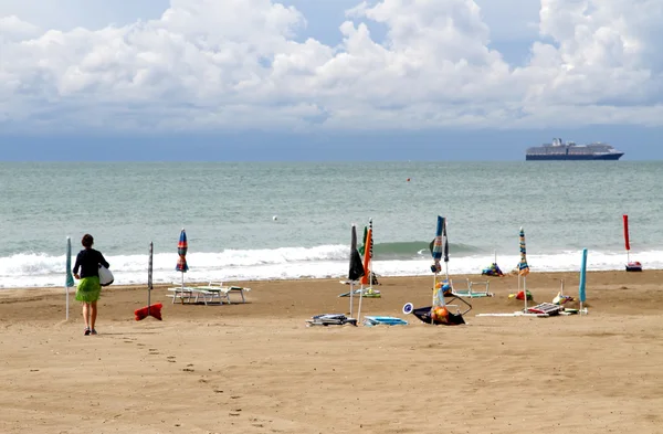 Woman who arrives on the beach and a cruise ship — Stock Photo, Image