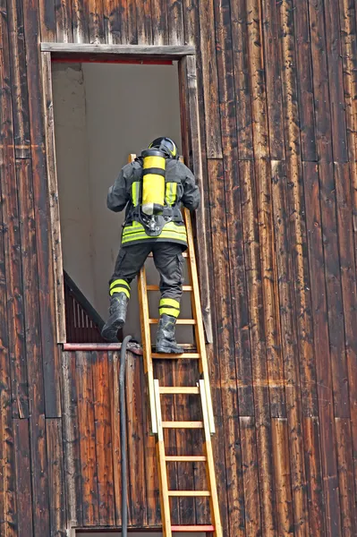 Strażak z butli tlenowej podczas ćwiczenia strażackie w firehous — Zdjęcie stockowe