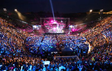 Verona, VR, Italy - June 5, 2017: Live concert inside the Ancient Roman Arena with many people and stage clipart