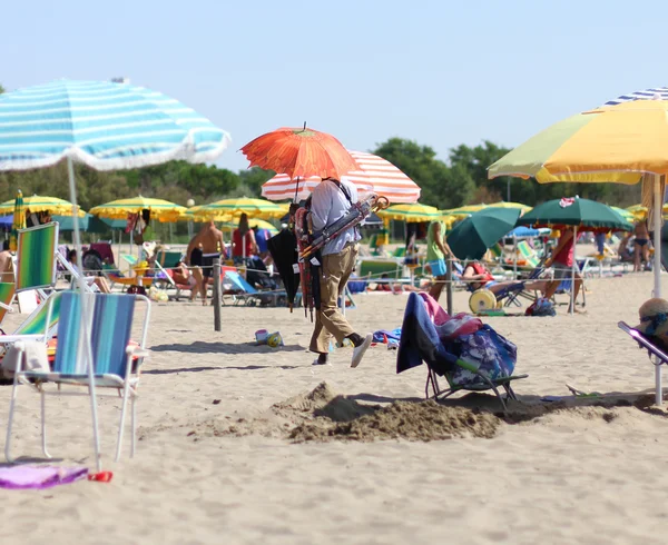 Abusive umbrella seller on the sea beach with umbrellas — Stock Photo, Image