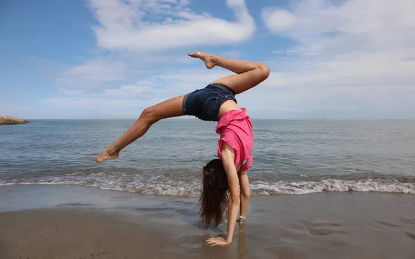Jong Meisje Doet Een Spin Achterwiel Tijdens Oefeningen Aan Zee — Stockfoto