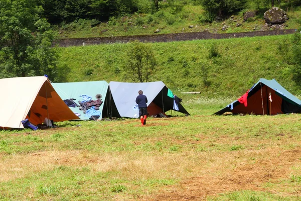 Młody harcerz spacery wśród namiotów — Zdjęcie stockowe
