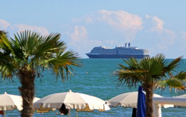 plaj şemsiyeleri sahilde ve yolcu gemisi